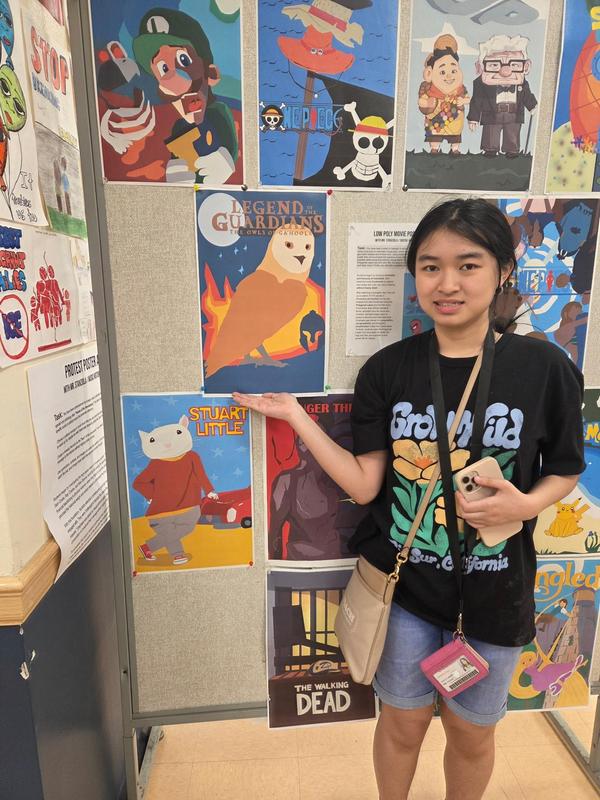 a student pointing towards her art