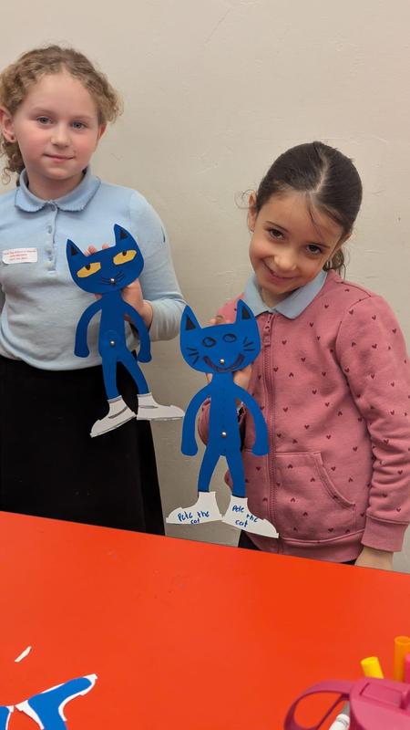Two students show off their paper puppets.