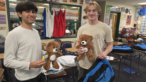 Two teenage boys holding brown teddy bears