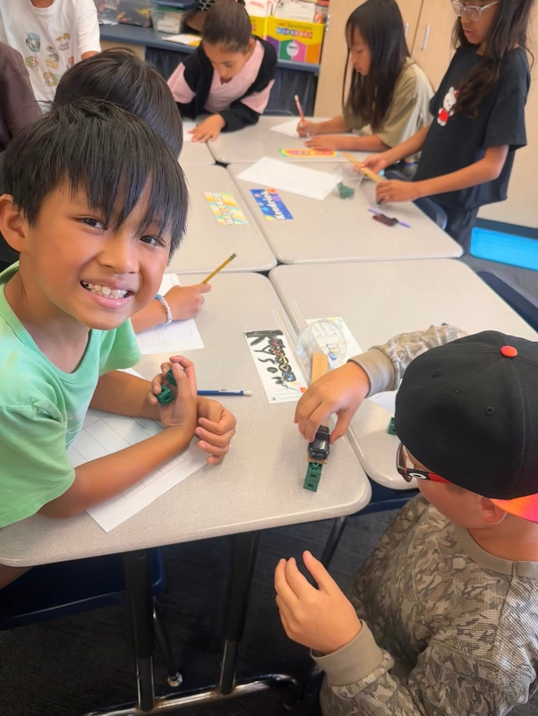 Children engaged in arts and crafts activities at a classroom table.