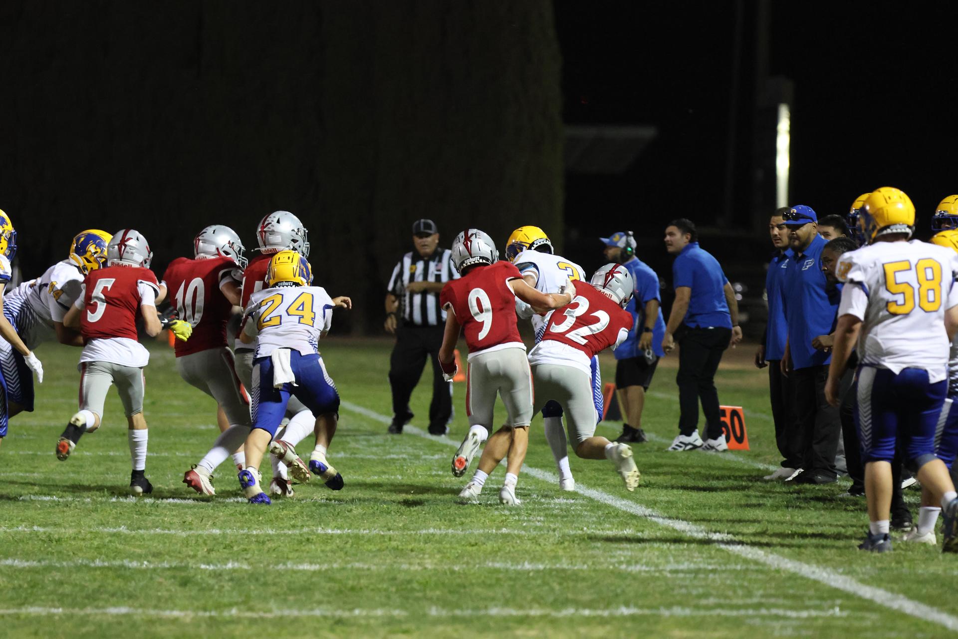 Varsity football players in action against Parlier 36