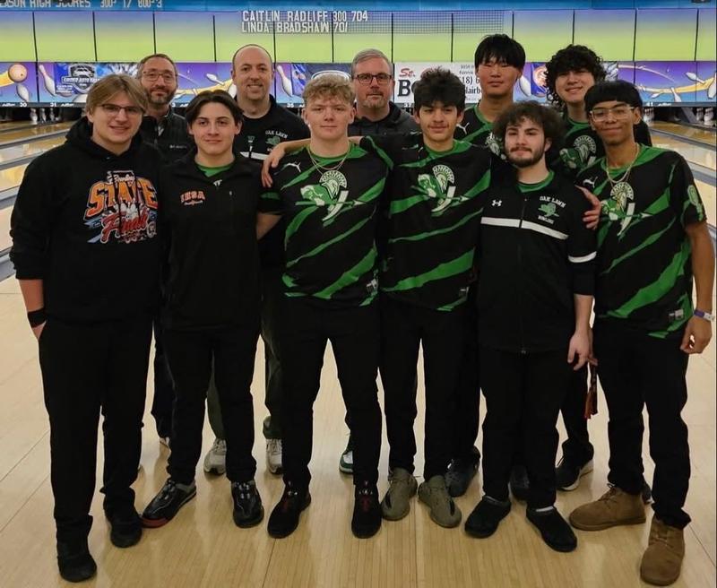 group of young men and pose in front of a bowling lane