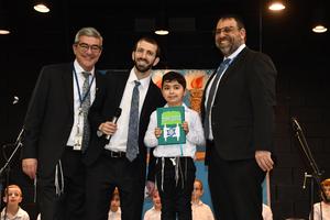 A first grade boy recieves his Siddur