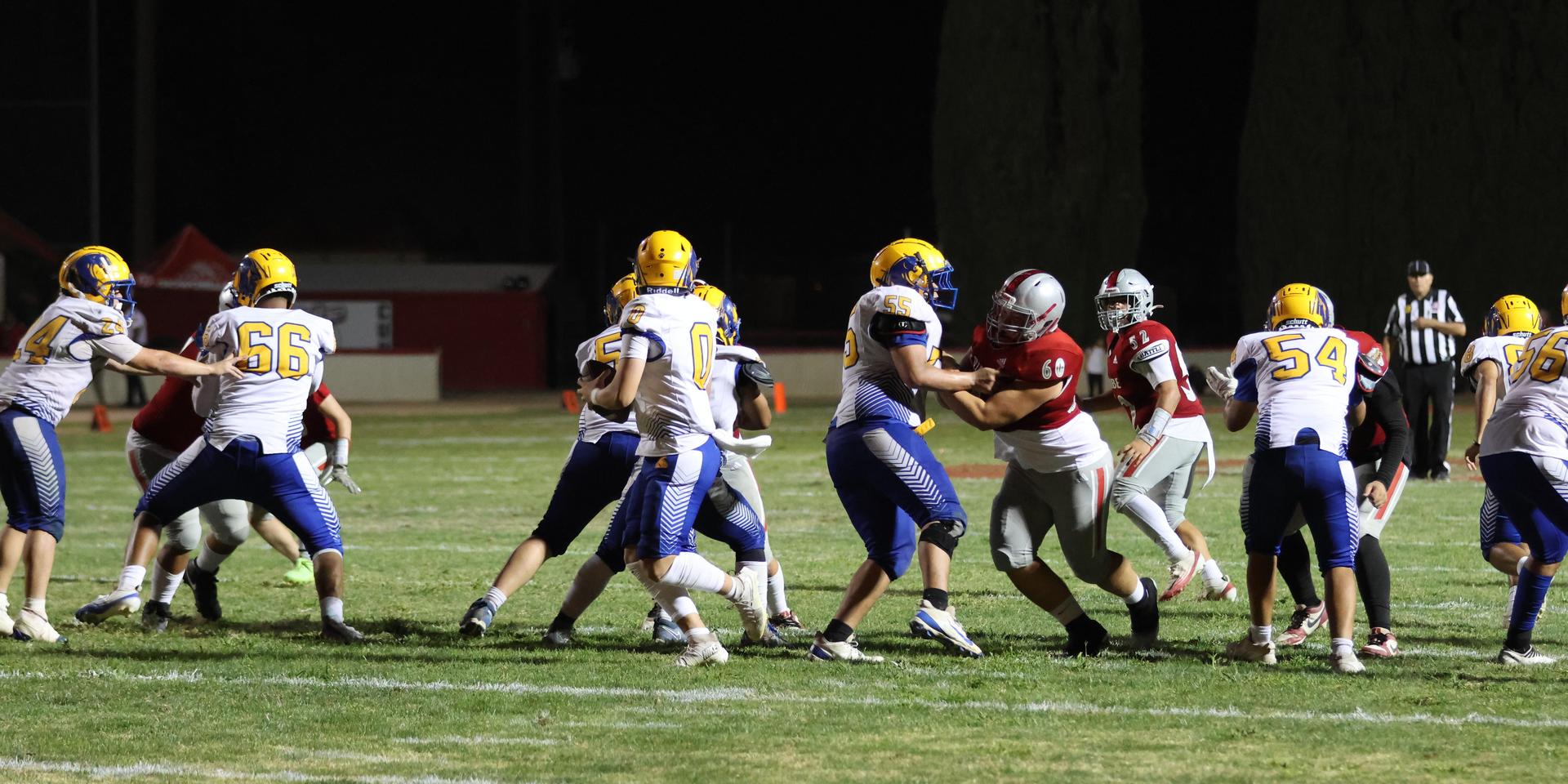 Varsity football players in action against Parlier 81