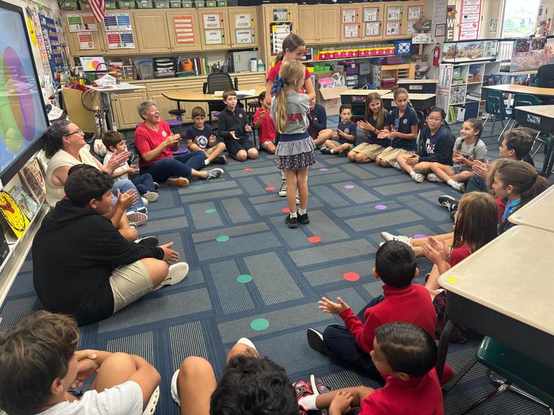 Students in grades Tk-8 sitting in circle playing a game