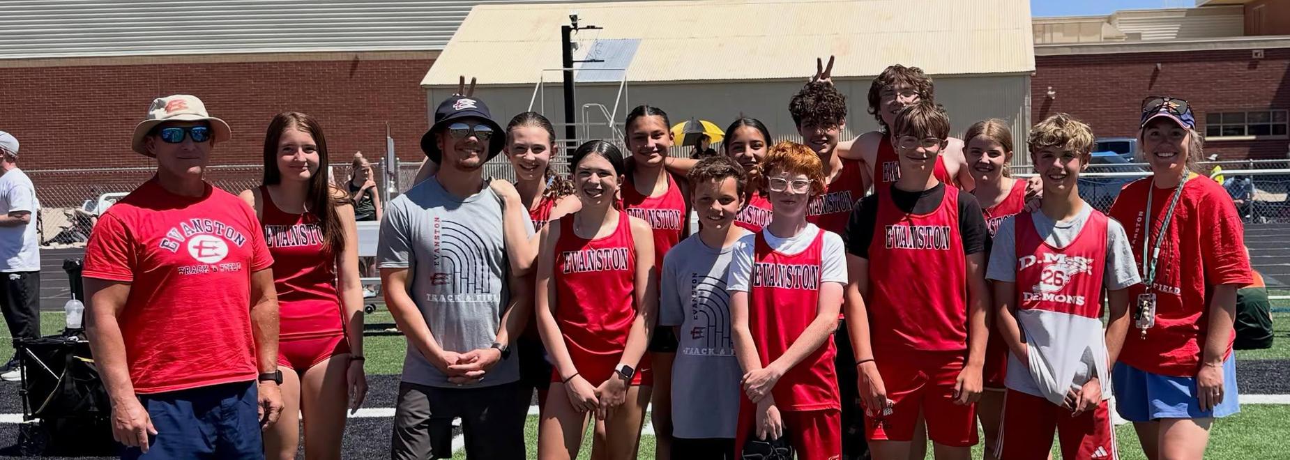 Group of students and coaches posing together in athletic attire.
