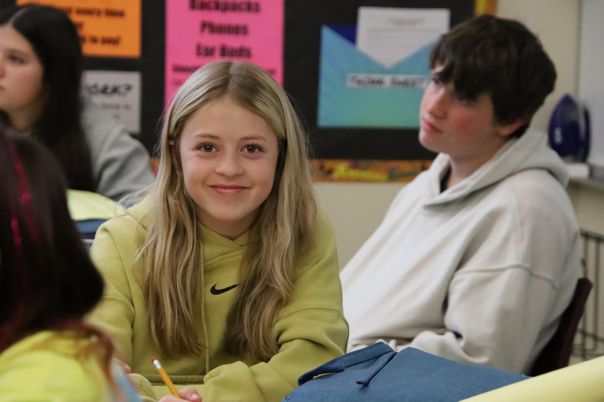 middle school girl smiling at camera in the classroom