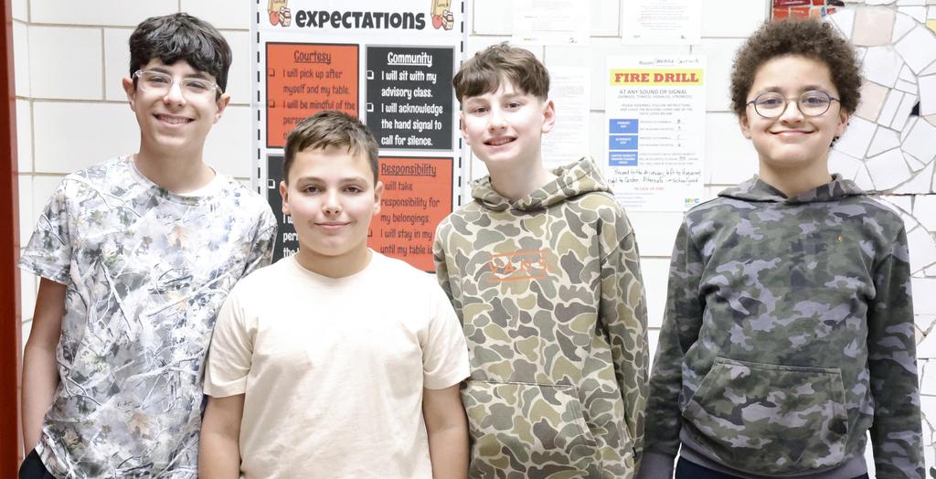 Four boys wear camouflage clothing.