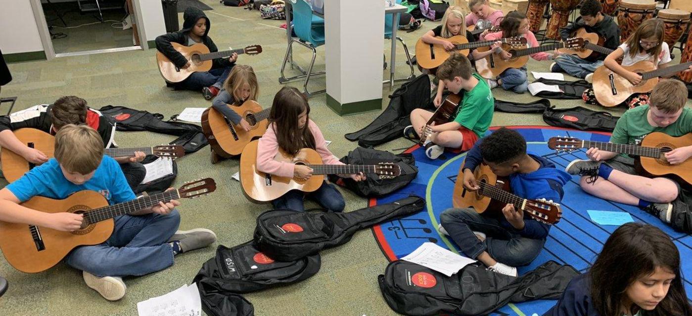 students learning to play guitar