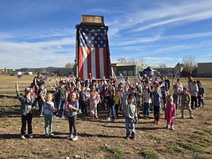 Kids cheer with flag on semi in the background