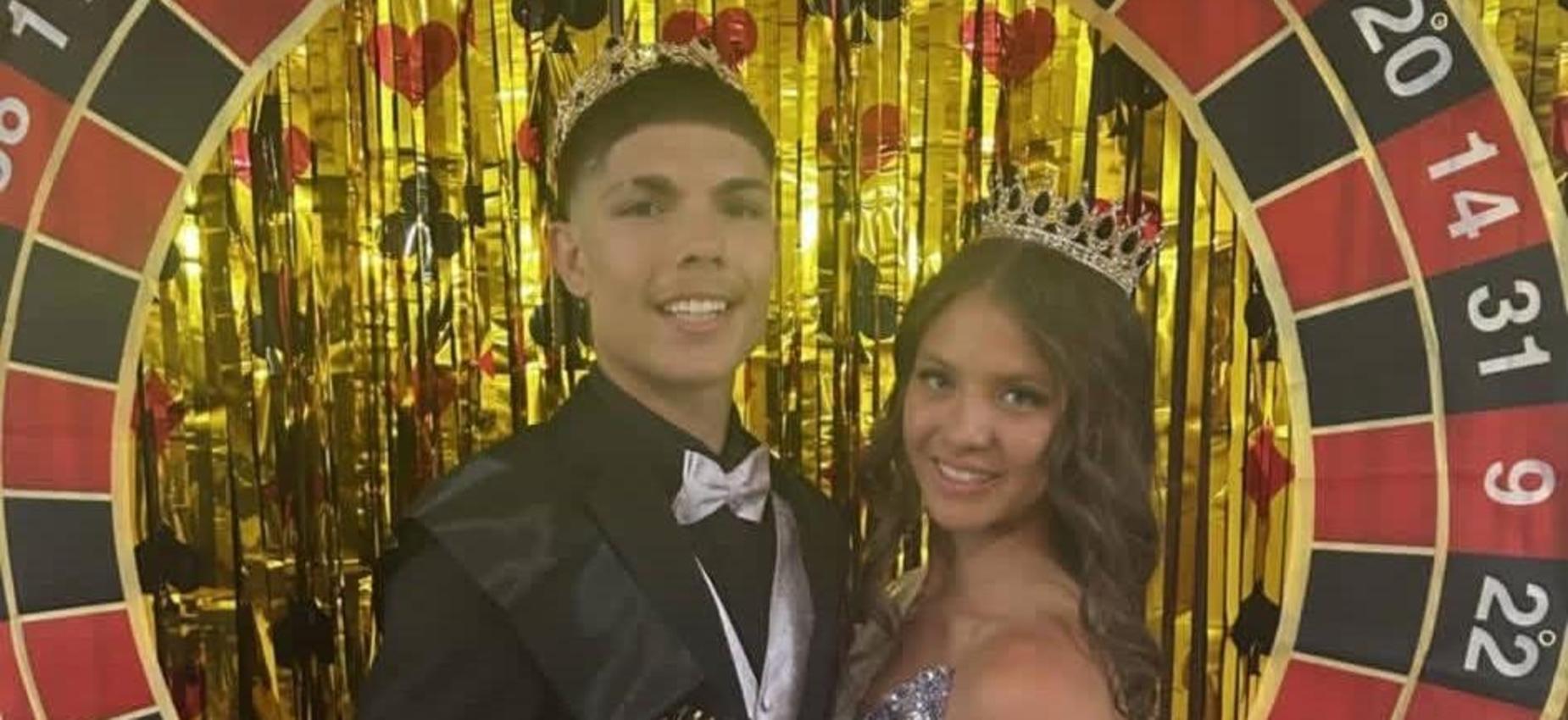 Prom king and queen in front of casino wheel decor