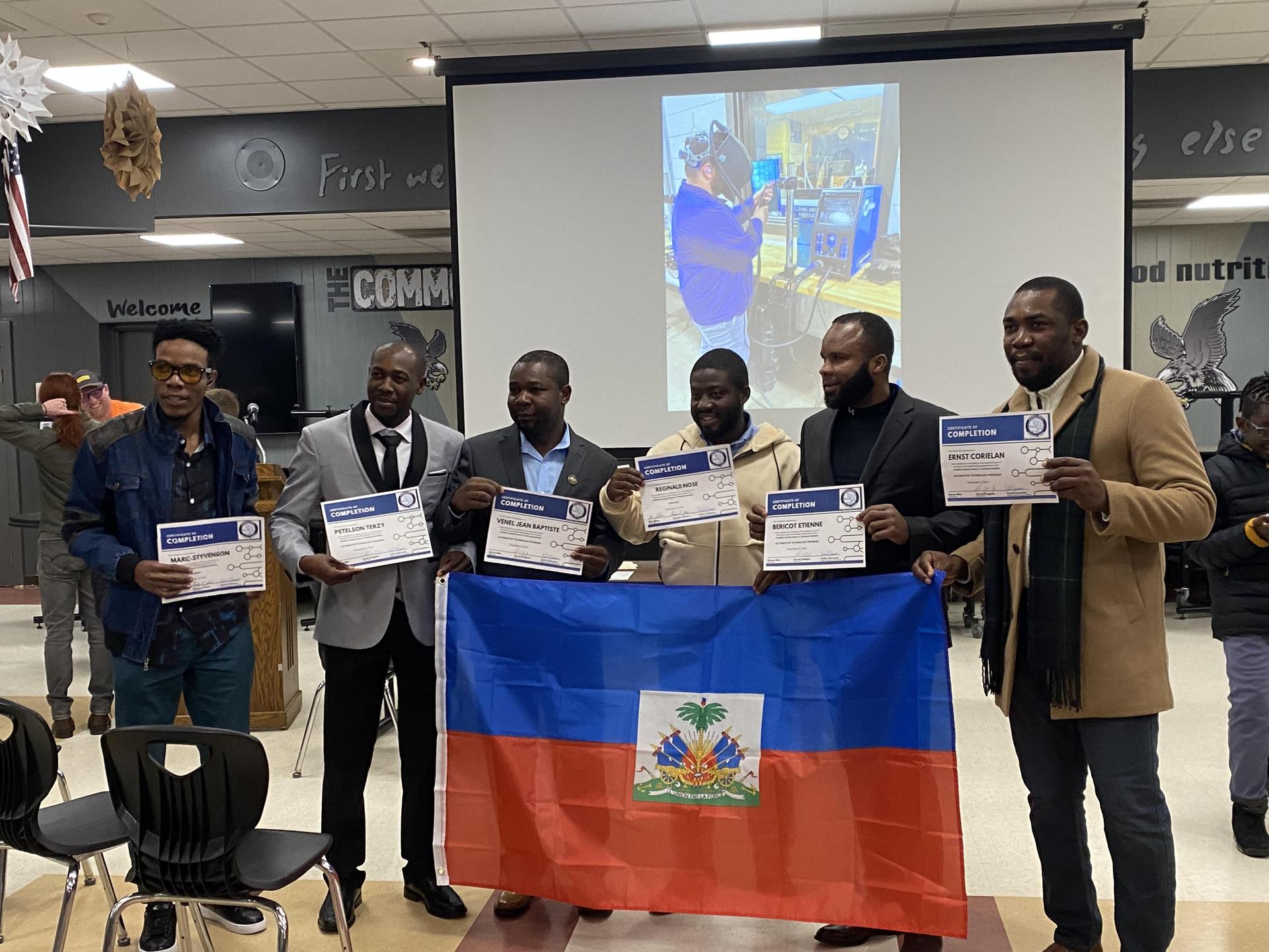 Hatian Grads standing with flag