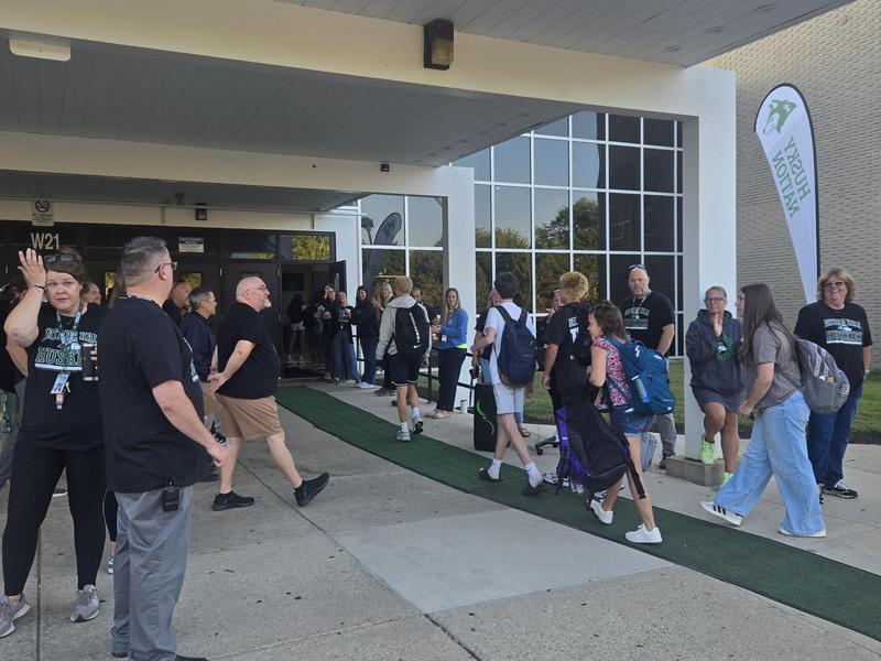 Crowd of people entering a school building during an event.