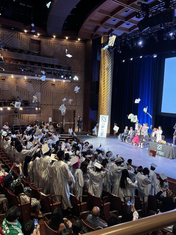 Graduates throw their caps in celebration during the graduation ceremony.