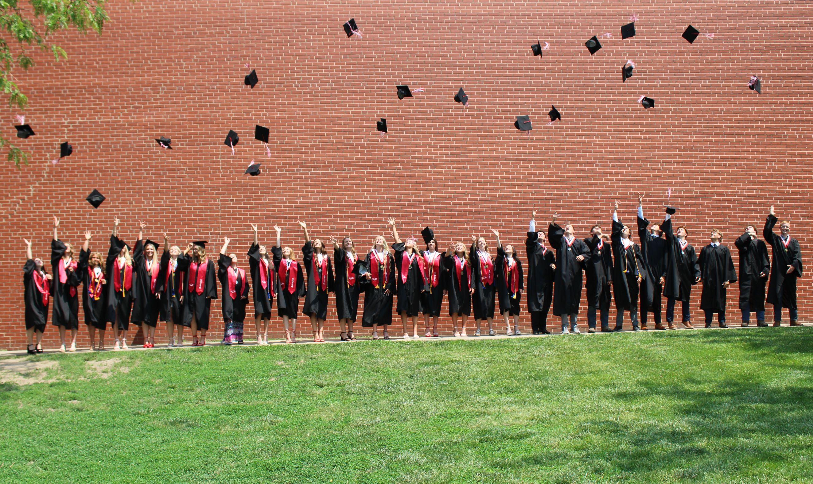 Graduating Class of 2026 tossing their hats in the air.