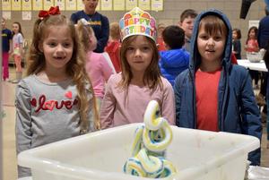 three children watching a small elephant toothpaste experiment