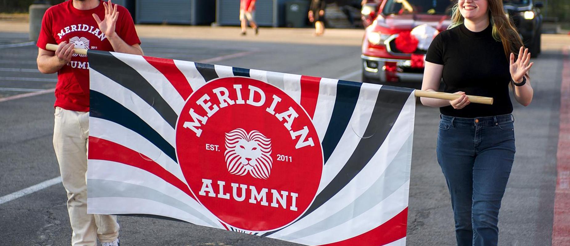 Alumni hold a banner at the HoCo Parade