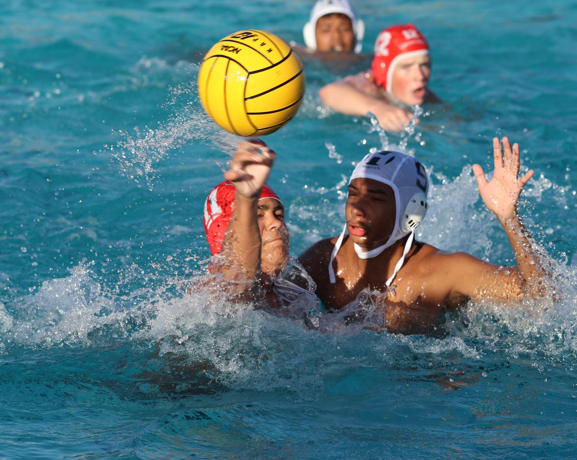 boys water polo players in action against hoover