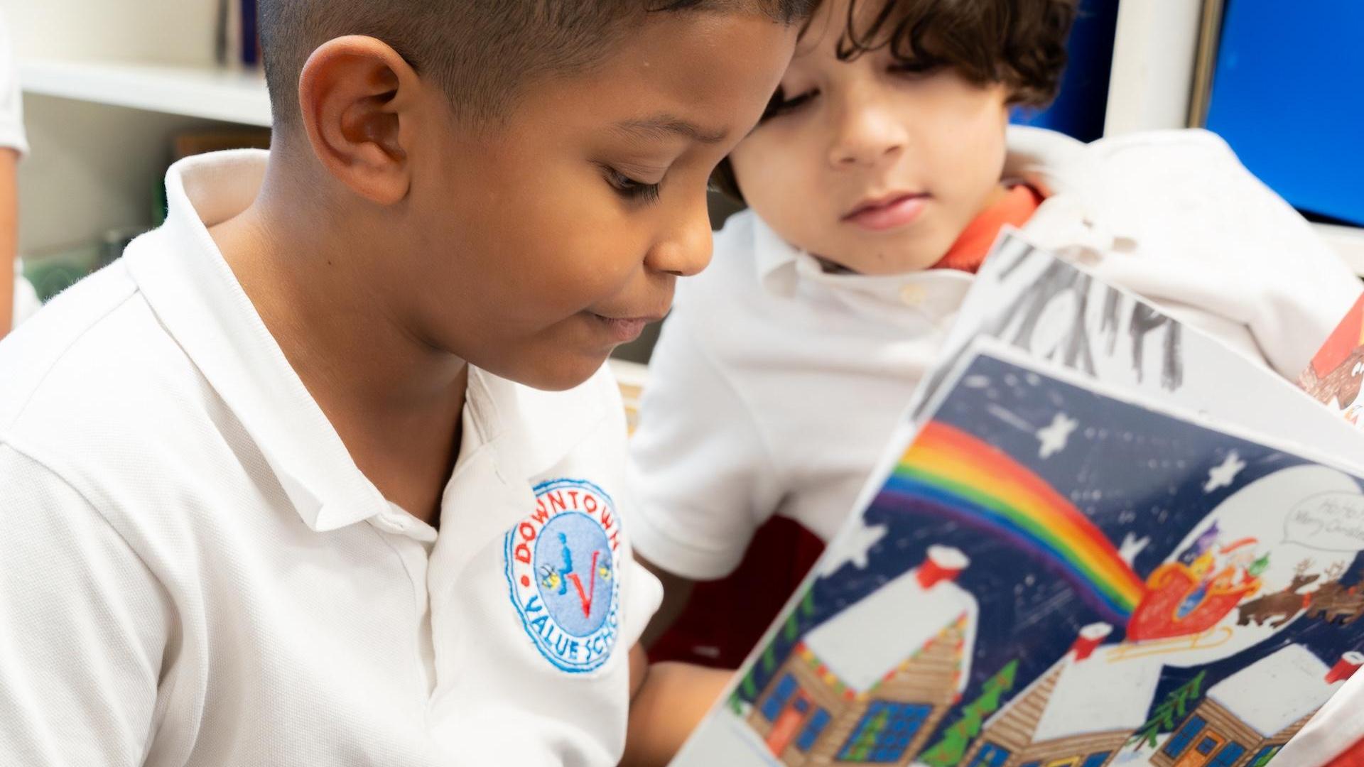 Two boys looking at a colorful storybook together.