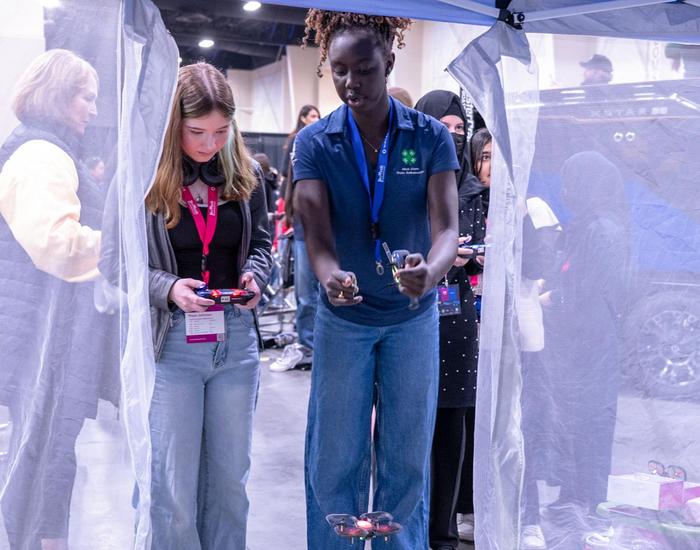 student helping another student use a drone