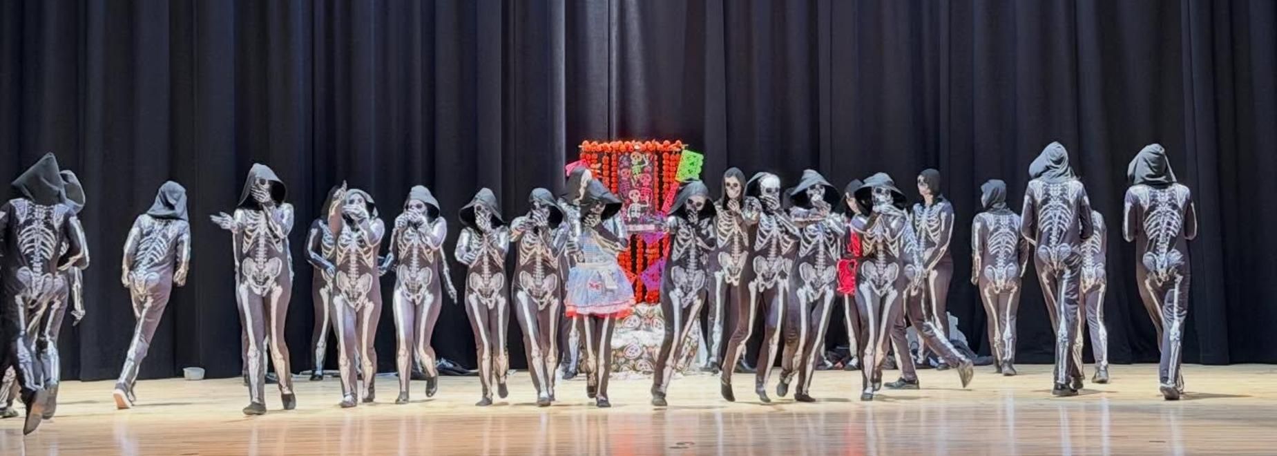 Performance stage featuring figures in costumes with a colorful backdrop.