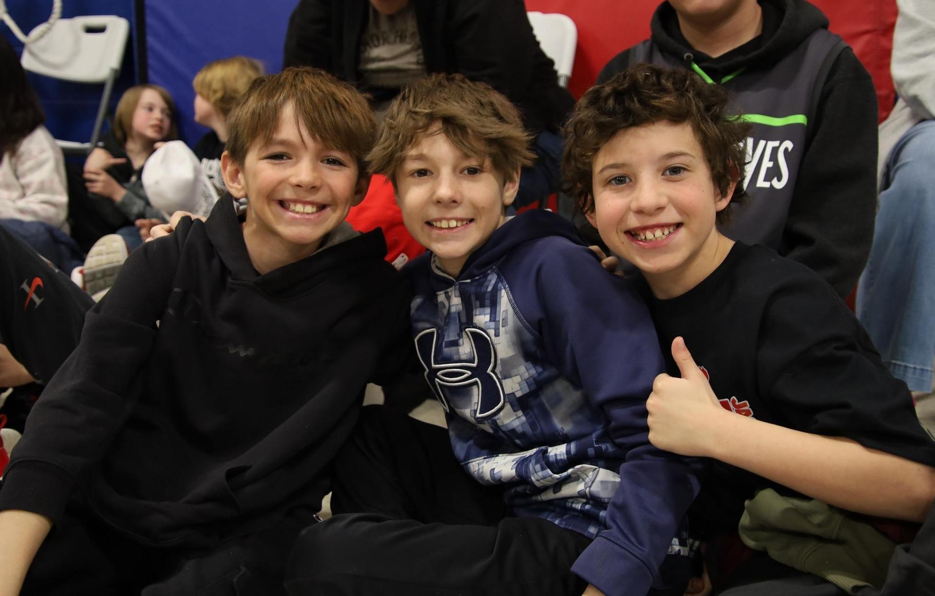 Three elementary school boys posing and smiling for a photo