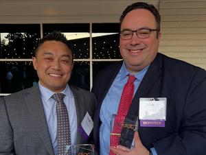 a close up of two mock trial coaches with their awards