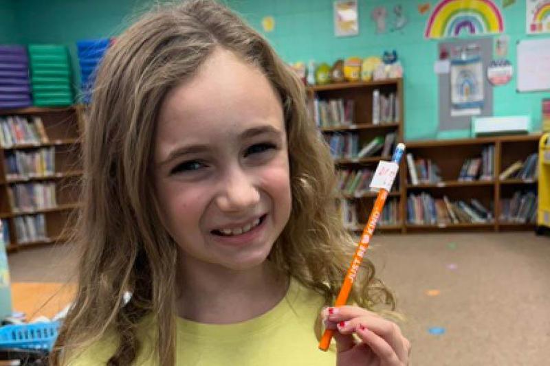 a student holds a pencil