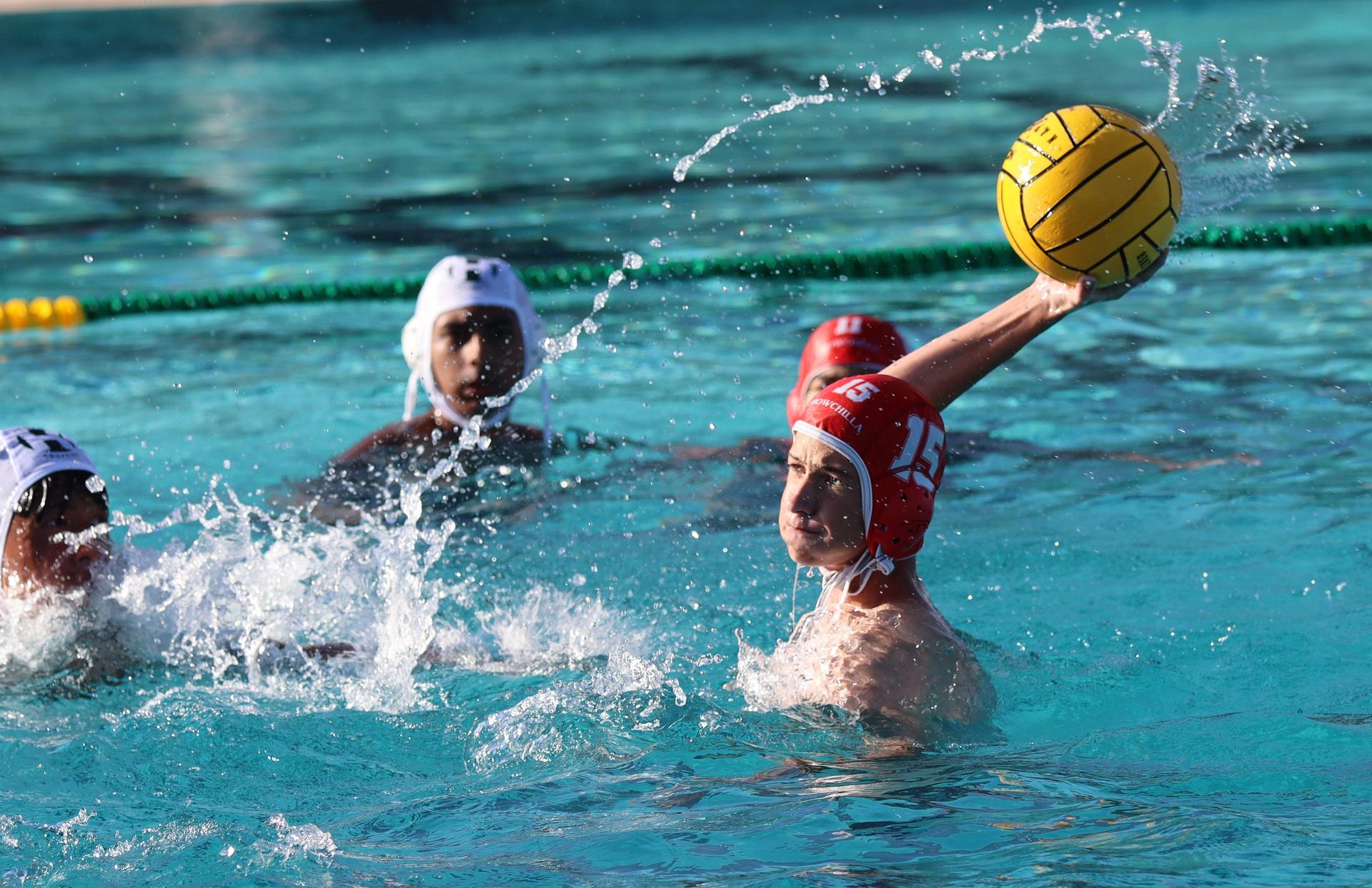 boys water polo players in action against hoover