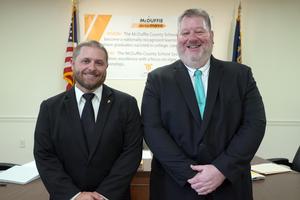 New principals Brock Hawkins and James Meneguzzo pose in the board of education meeting room.