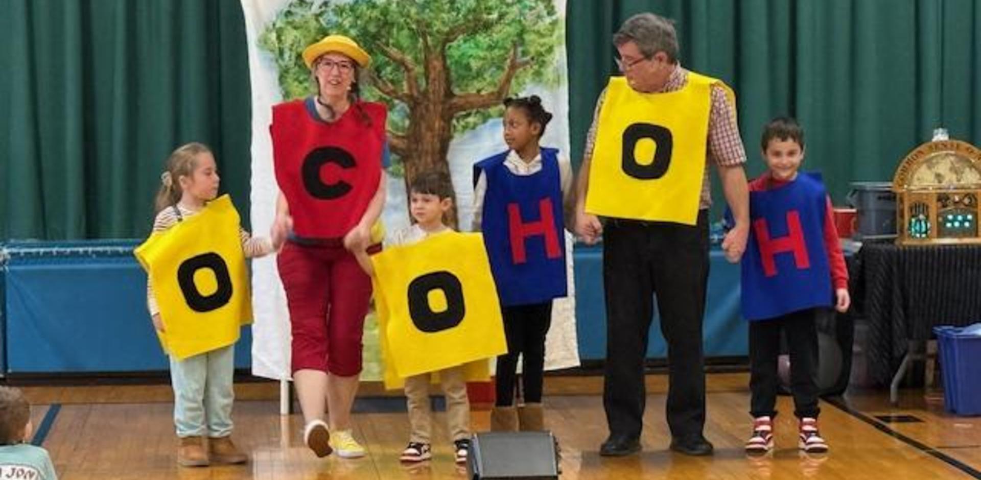 Participants displaying colorful letters during a community performance.