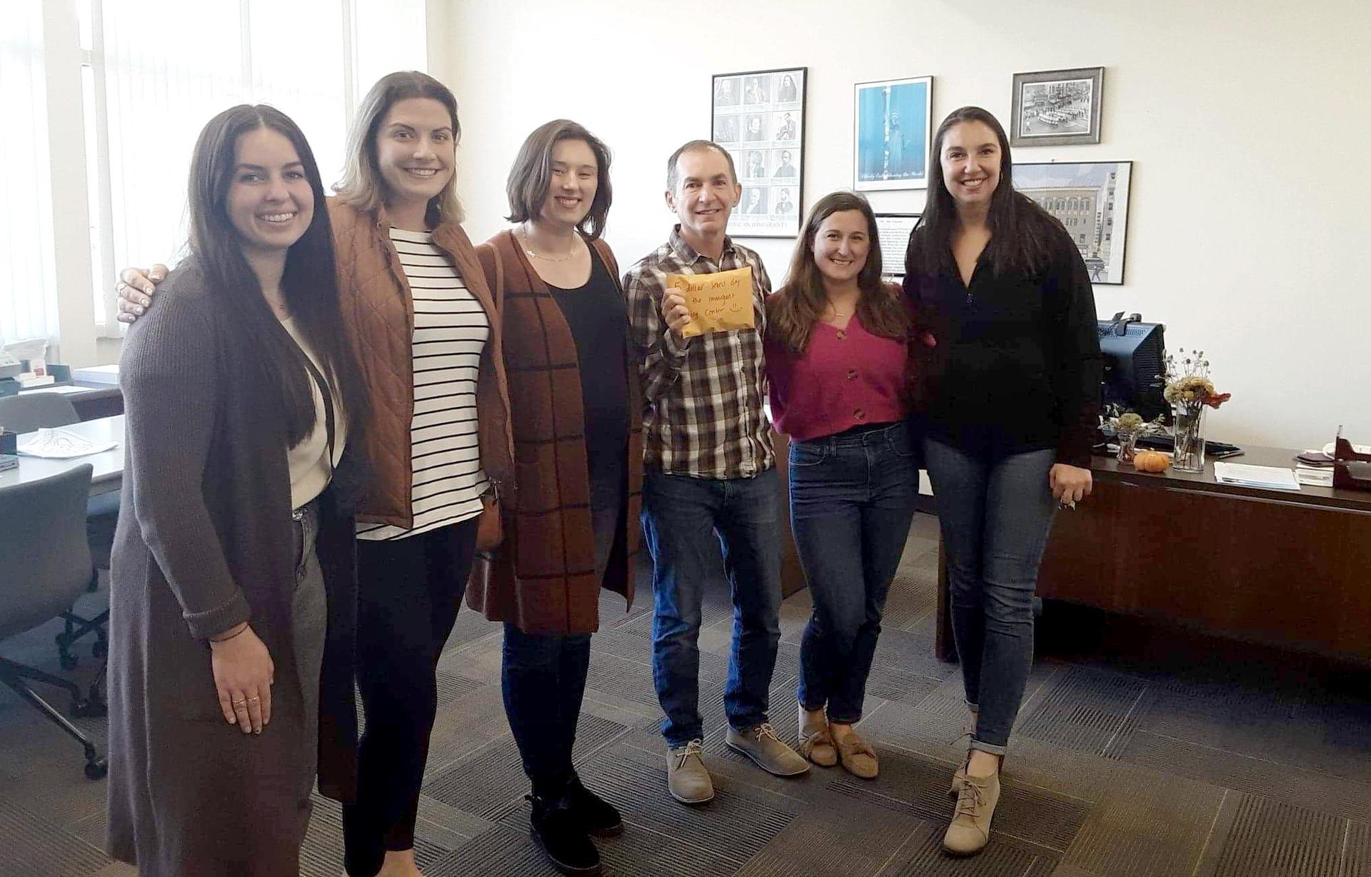 A group of adults standing inside an office