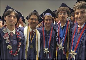 A group of graduates pose in their cap and gown