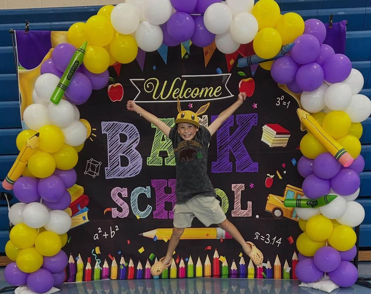 a student leaps with excitement in front of a back to school display at RES