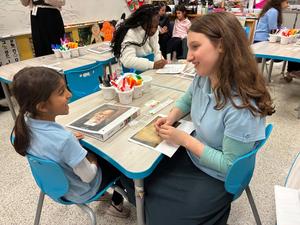 a seventh grade girl read her Gadol picture book to a kindergarten student.