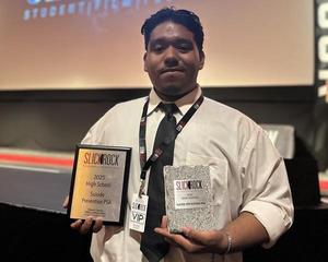 Ramses Gomez proudly holds his award plaque and glass trophy for first place in the Suicide Prevention PSA category at the Slick Rock Film Festival.