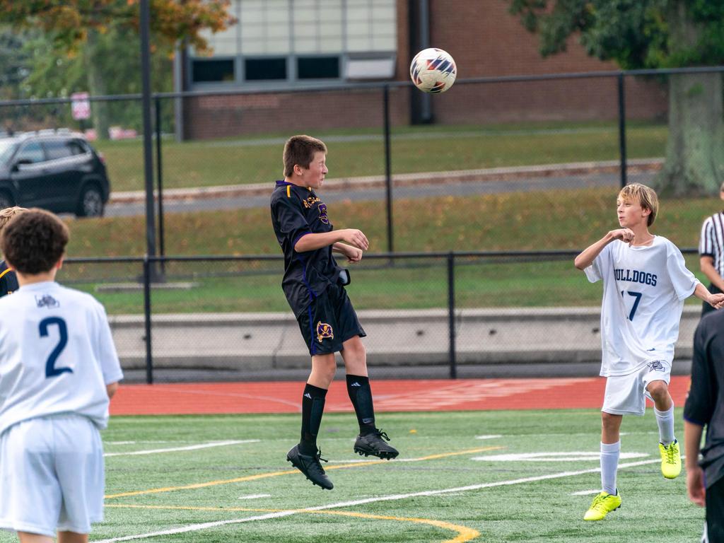 A soccer player hitting the ball with his head during a match.