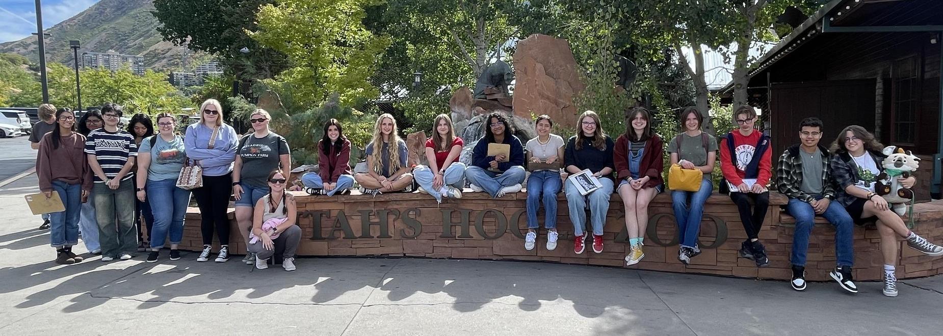 A diverse group of people posing together outdoors in a park setting.