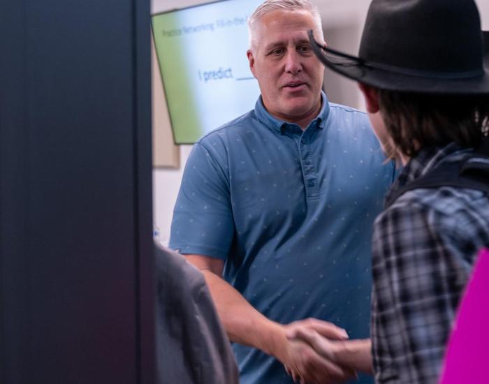 teacher welcoming student with handshake