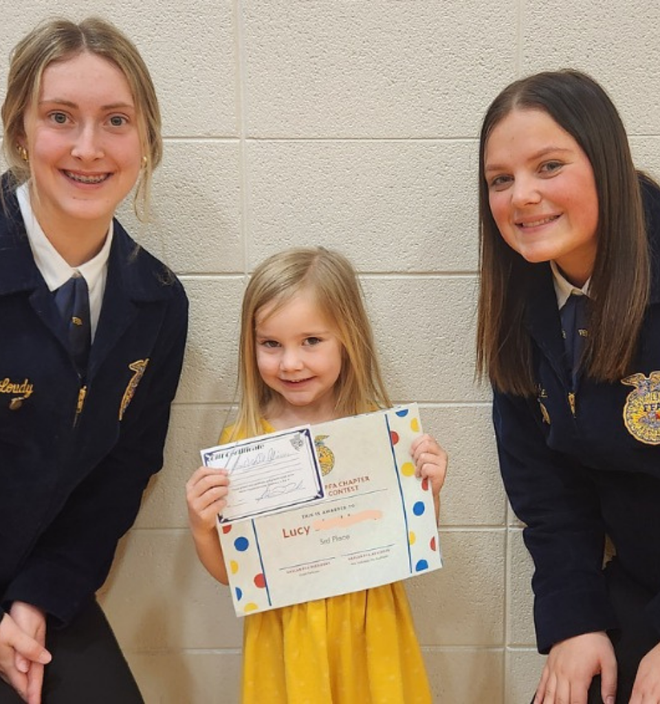 Two girls and a young girl holding a certificate, smiling at the camera.
