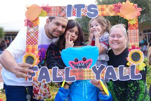 family posing behind a It's Fall Y'All border