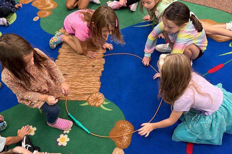 Lexi Kowalkowski, Adeline Jack, Addyson Hitchen, and Lucy Pavlovic work together to make the letter “O”