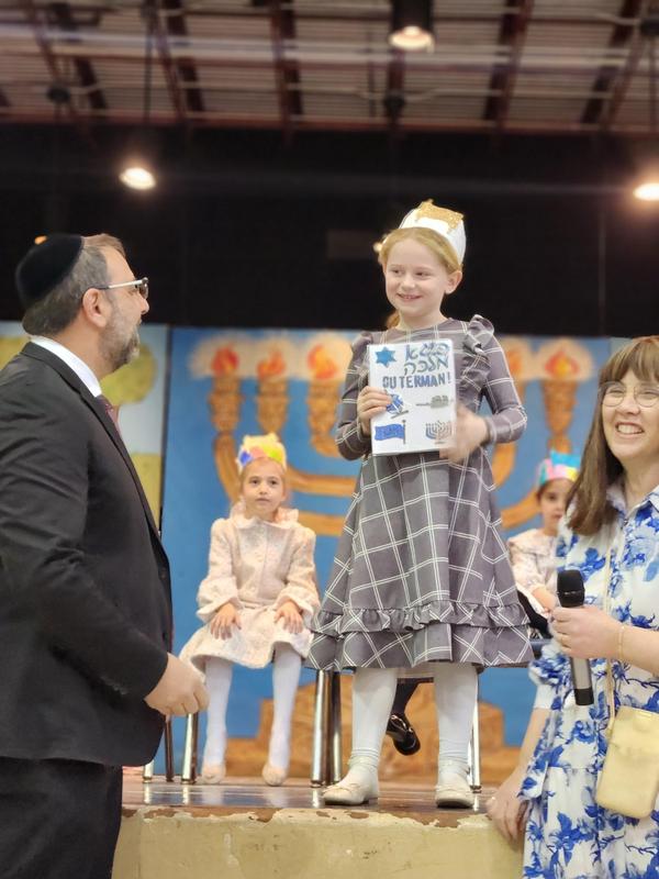 A proud student receives her chumash.