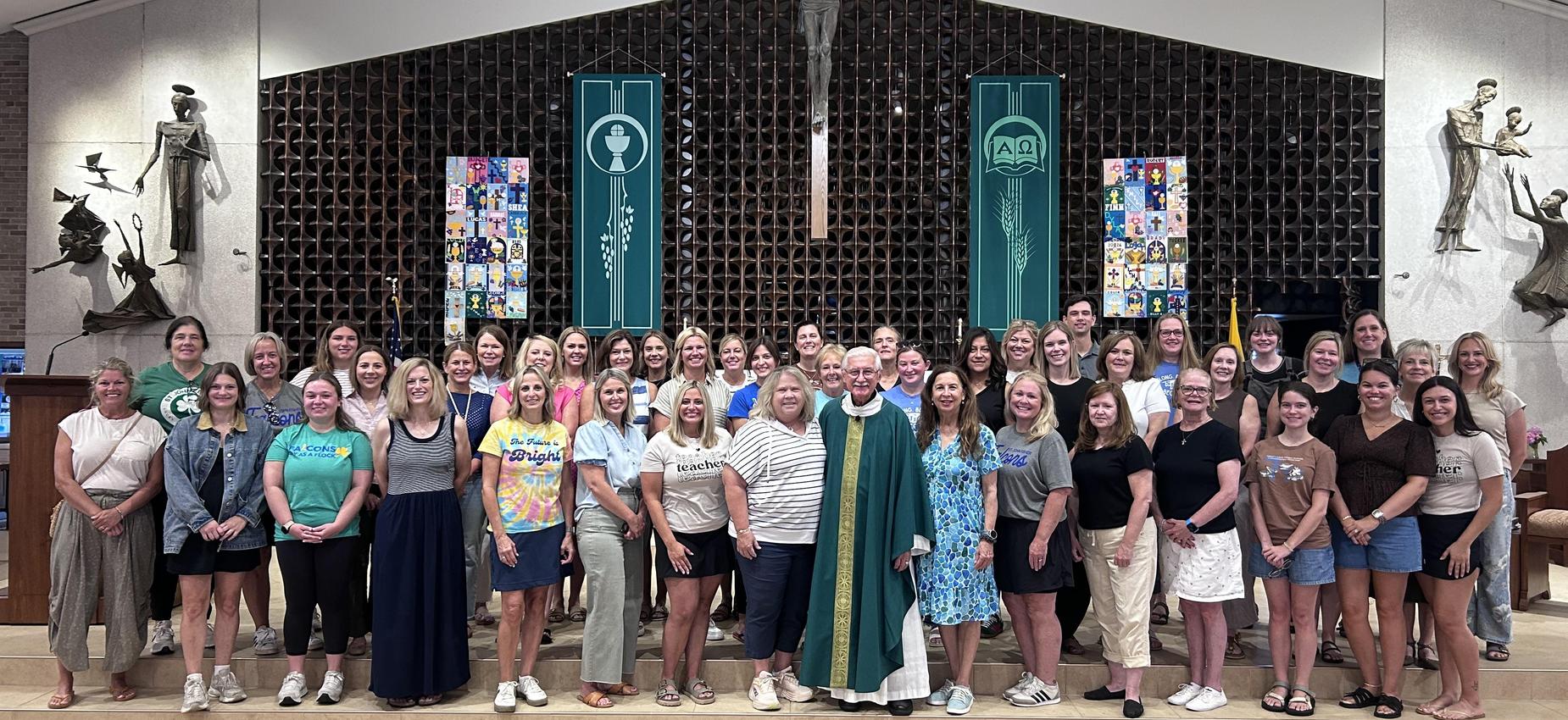 A large group of people posing together in a church setting, smiling.