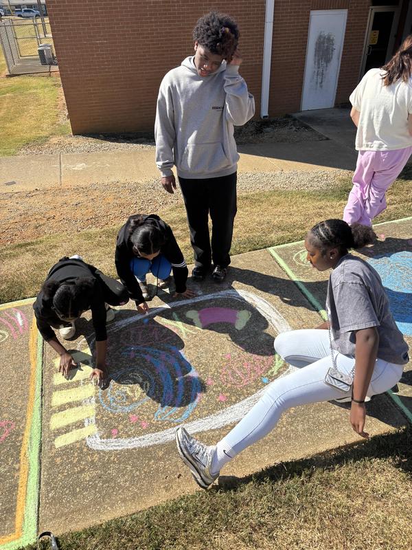 Group of students working on sidewalk art of the cell