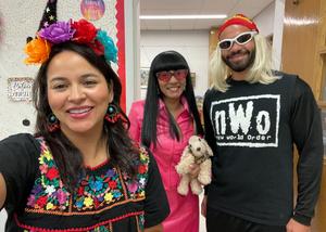 Staff dressed in costume taking group photo. Mr. Psoras dressed as WWE Wrestler.