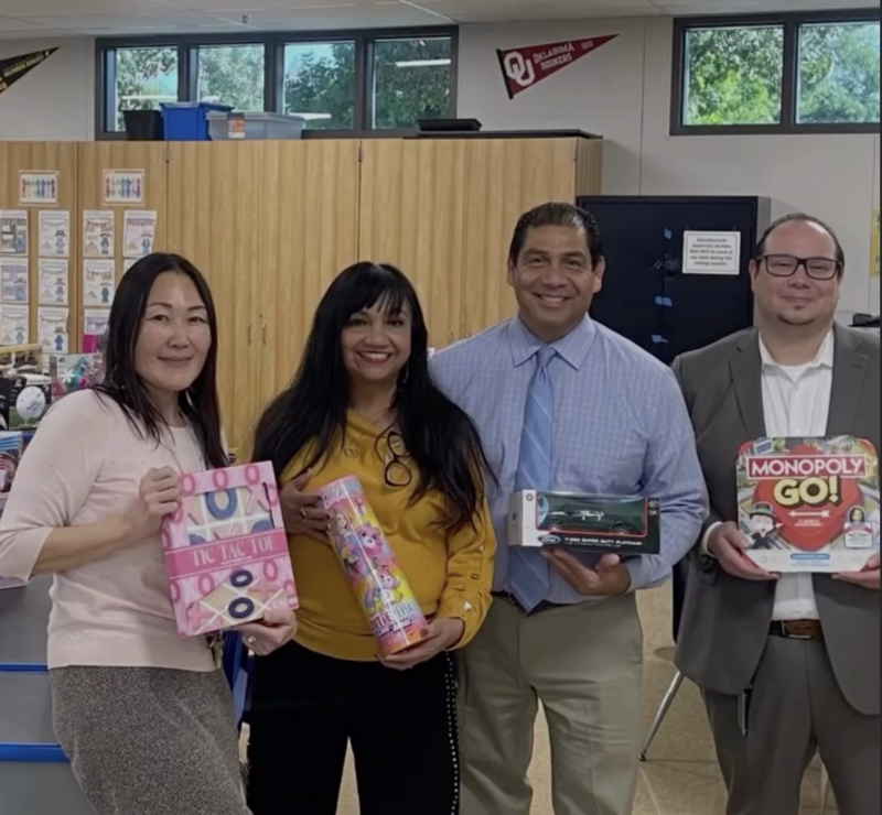 four persons posing with holiday gifts