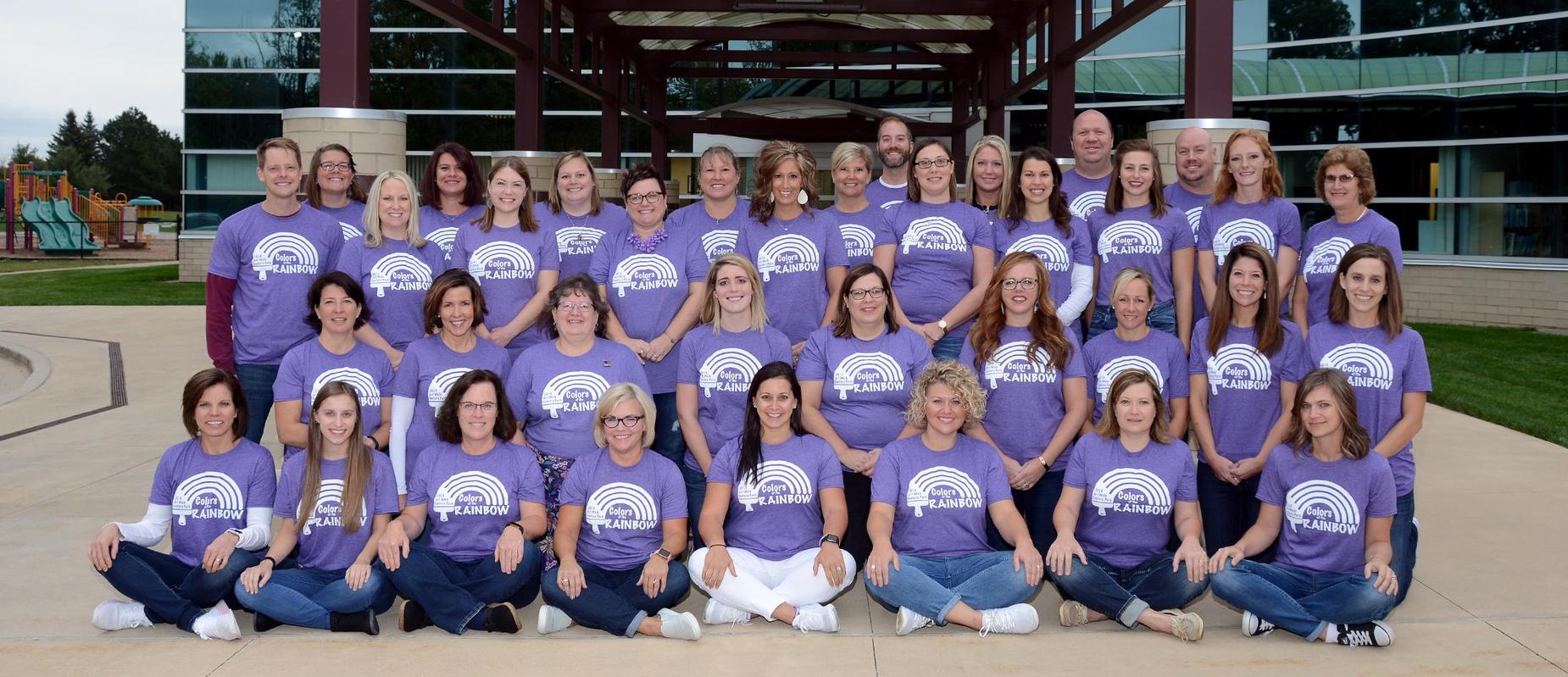 staff of Century Park sit outside in front of school