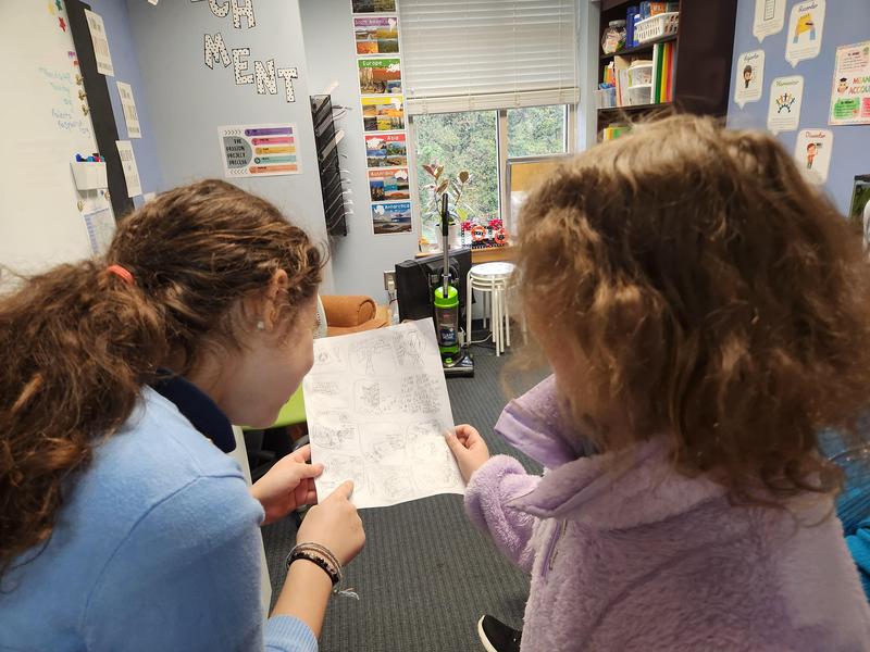 MSG girls go over a submission to the newspaper
