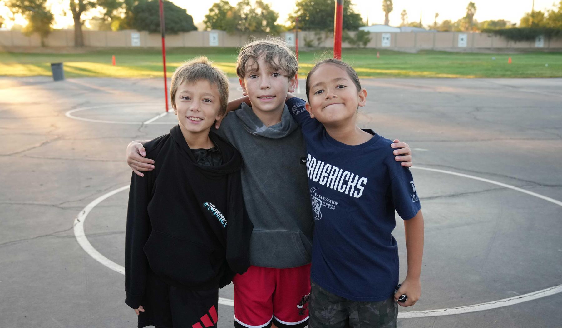 three elementary school boys on blacktop playground